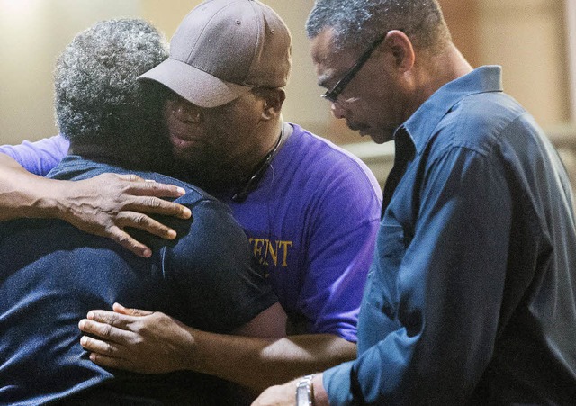 Mitglieder der Kirche trsten nach dem Anschlag einander.  | Foto: AFP
