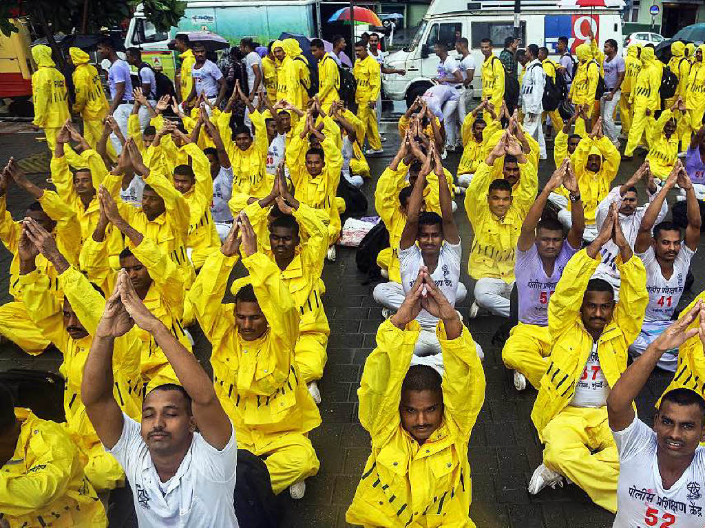 Indische Polizisten in Mumbai bten im Regen Yoga