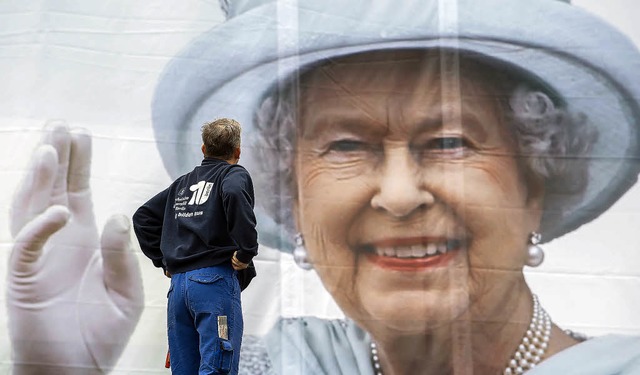 Die Queen winkt von einem Plakat, das ...ersitt Berlin angebracht worden ist.   | Foto: dpa