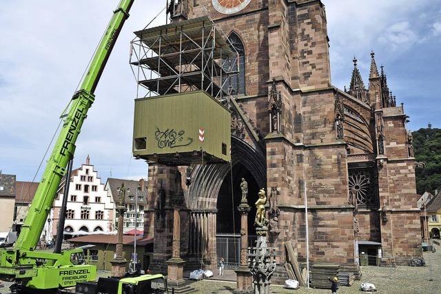 Ein Kranwagen verschiebt ein Baugerst vor dem Freiburger Mnster