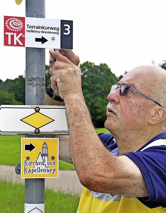 Gerd Benz bringt ein neues Wanderwegschild an.   | Foto: Stefan Pichler