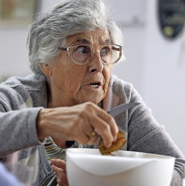 Eine an Demenz erkrankte Frau schneidet Zwetschgen.    | Foto: dpa