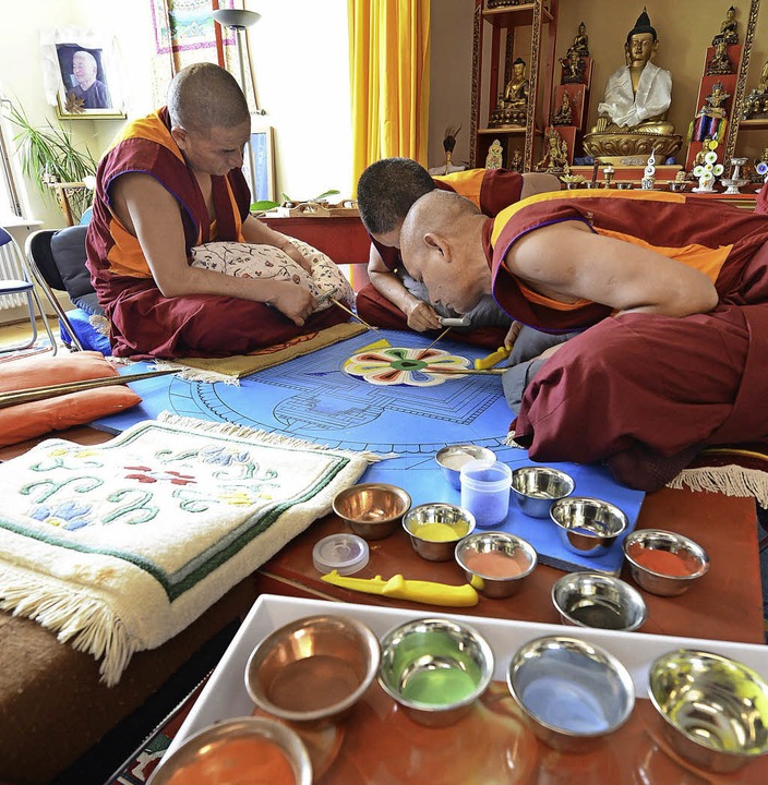 Mönche aus Indien streuen ein Mandala .... Als Motiv zeigt es eine Lotosblüte.   | Foto: Rita Eggstein