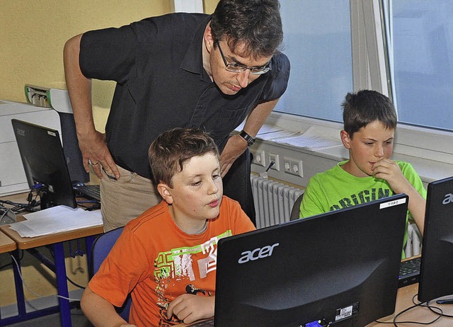 Ein Vater sieht zu, wie sein Sohn am Computer arbeitet.   | Foto: S. Pichler