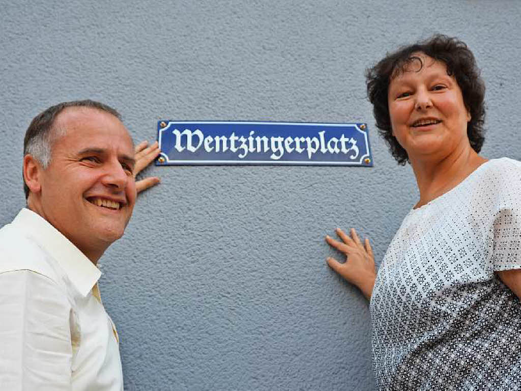 Thomas Breig und Claudia Dischinger montieren das neue Schild an die Wand des Alten Rathauses.