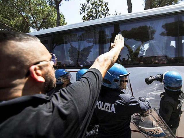 Ein Mann zeigt in Casale San Nicola be...ngen in einem Bus den Faschistengru.   | Foto: dpa