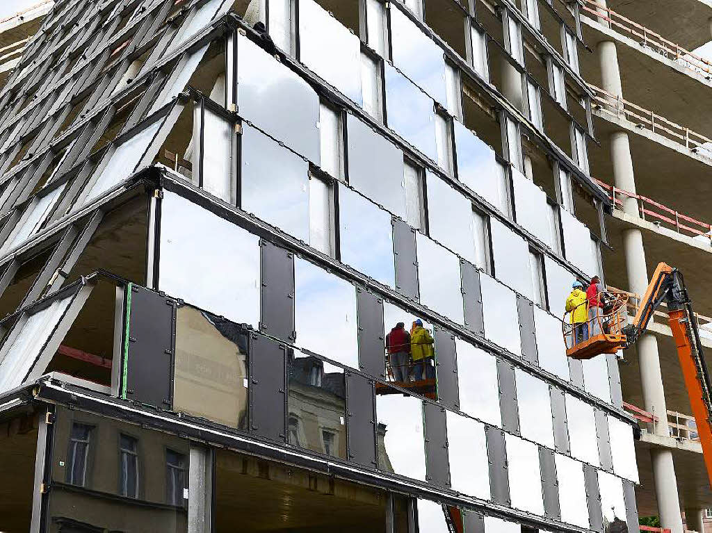 Ab Mai 2013 wurden puzzleartig mehr als 7300 Quadratmeter  Fassade aus Glas und Stahl montiert.