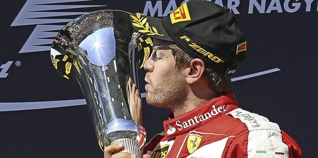 Stiller Jubel: Sebastian Vettel mit der Siegertrophe   | Foto: dpa