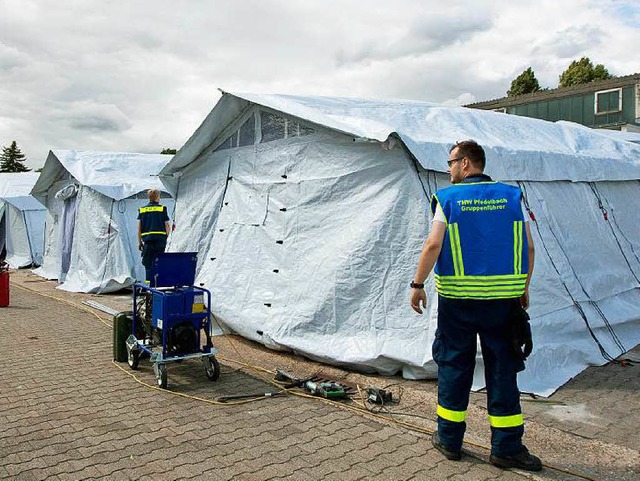 Mitarbeiter des THW bauen in Neuenstadt am Kocher ein Zelt fr Flchtlinge auf.   | Foto: dpa