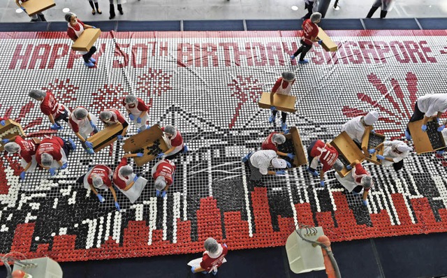 Freiwillige setzen aus Cupcakes ein Jubilumsmosaik zusammen.   | Foto: AFP