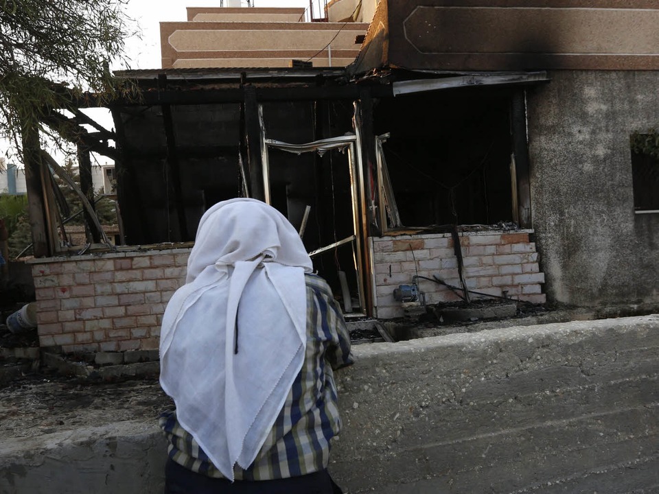 Trauer: Ein Palästinenserin blickt auf die ausgebrannte Ruine im Dorf Duma.  | Foto: dpa/Knaul