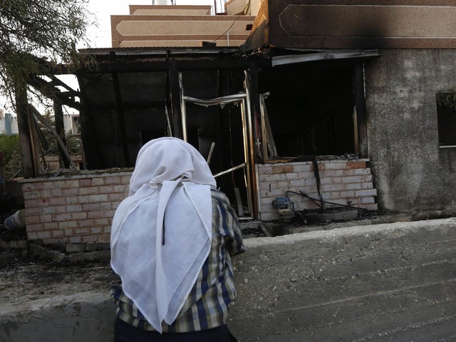 Trauer: Ein Palstinenserin blickt auf die ausgebrannte Ruine im Dorf Duma.  | Foto: dpa/Knaul