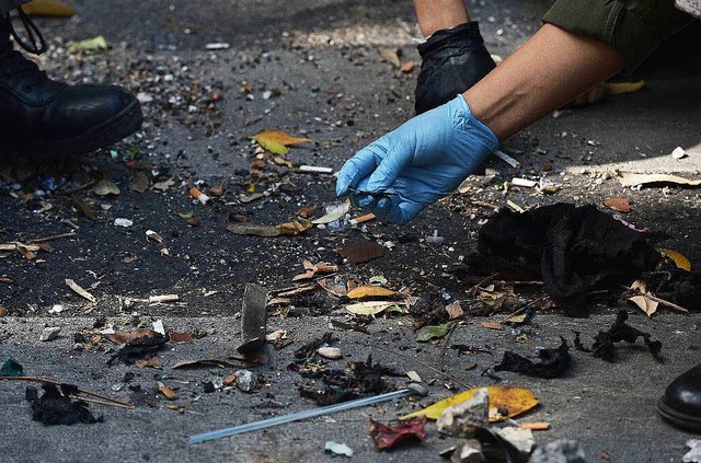 Polizisten suchen nach Spuren der Bombe, die 20 Menschen gettet hat.  | Foto: AFP
