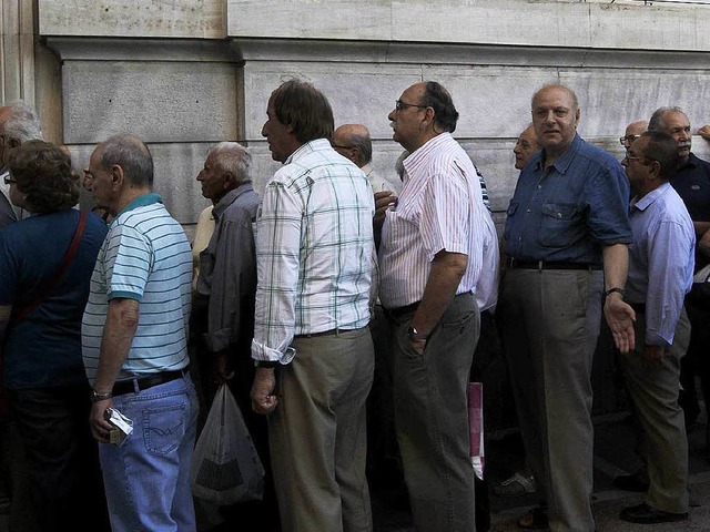 Griechen stehen im Juli Schlange vor einer Bank in Athen.  | Foto: dpa