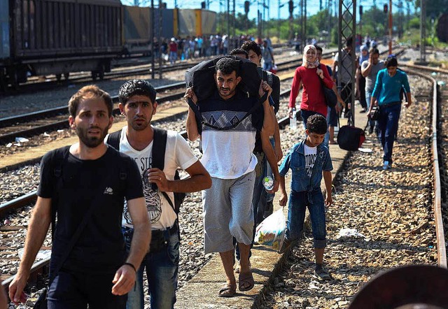 Zu Fu auf den Gleisen: Flchtlinge machen sich in Gevgelija auf den Weg.    | Foto: dpa
