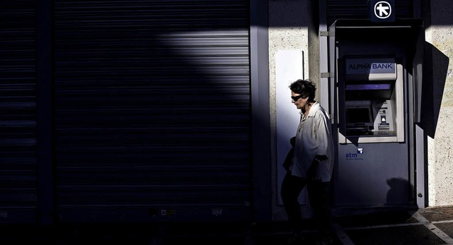Im Halbschatten &#8211; am Hhepunkt d...des Landes, der Alpha-Bank, in Athen.   | Foto: AFP