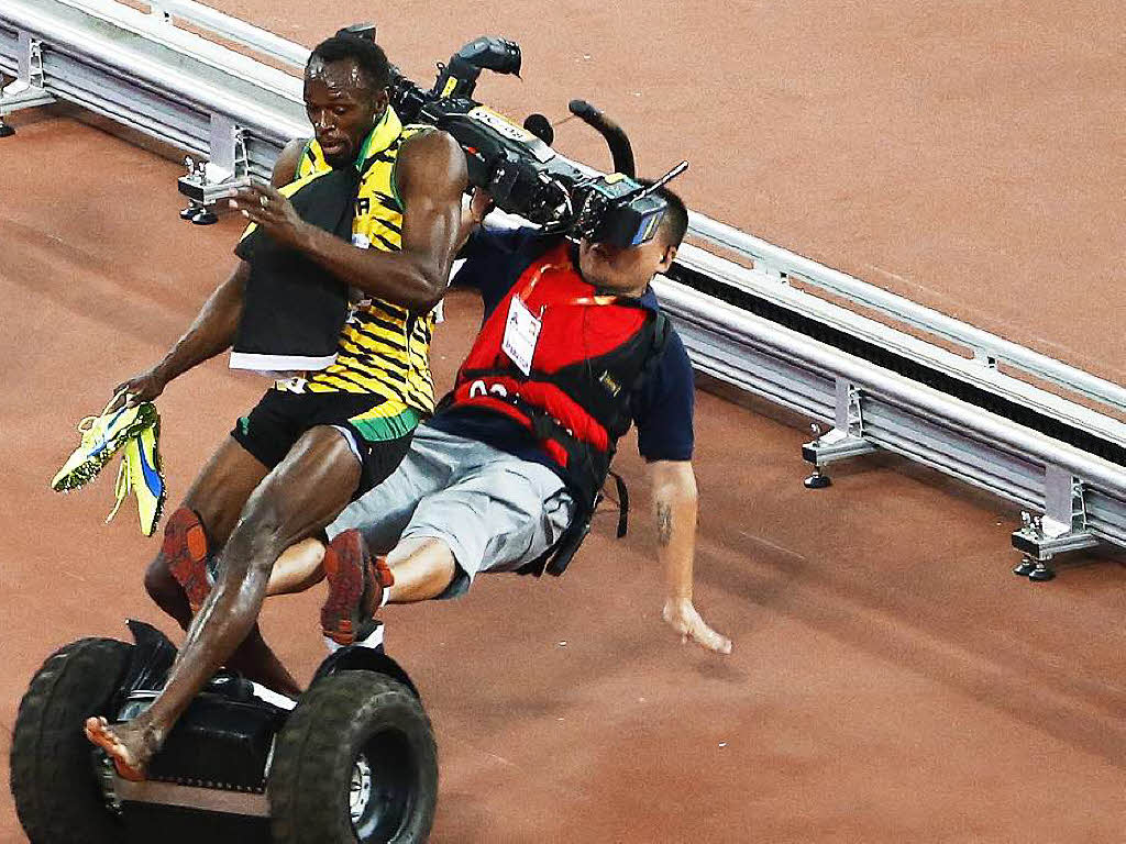 Nur einer kann Usain Bolt stoppen: Nach seinem Sieg ber 200 Meter wurde er von einem Kameramann auf einem Segway ber den Haufen gefahren.