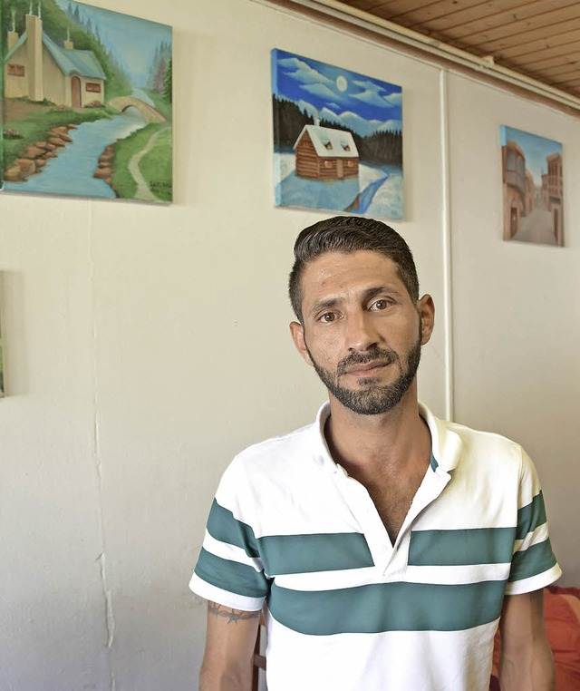 Saif Ali lebt seit knapp einem Jahr in...e, hinter ihm von ihm gemalte Bilder.   | Foto: Herwig Popken