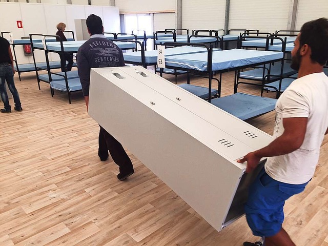 Asylbewerber aus Mannheim bauen die letzten Betten auf und tragen Schrnke.   | Foto: Adrian Hoffmann