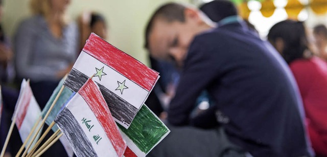 Die Fahnen Syriens und des Iraks stehe...dem Flchtlingskinder Deutsch lernen.   | Foto: dpa
