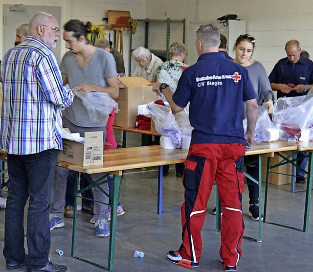 Viele eifrige Helfer verpacken Hygiene...n fr die Flchtlinge in der Region.    | Foto: Reinbold/DRK