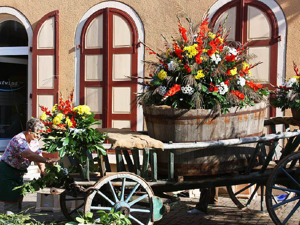 Bei den eingangs die Besucher begrenden Blumenwagen wird kurz vor der Festerffnung noch Hand angelegt