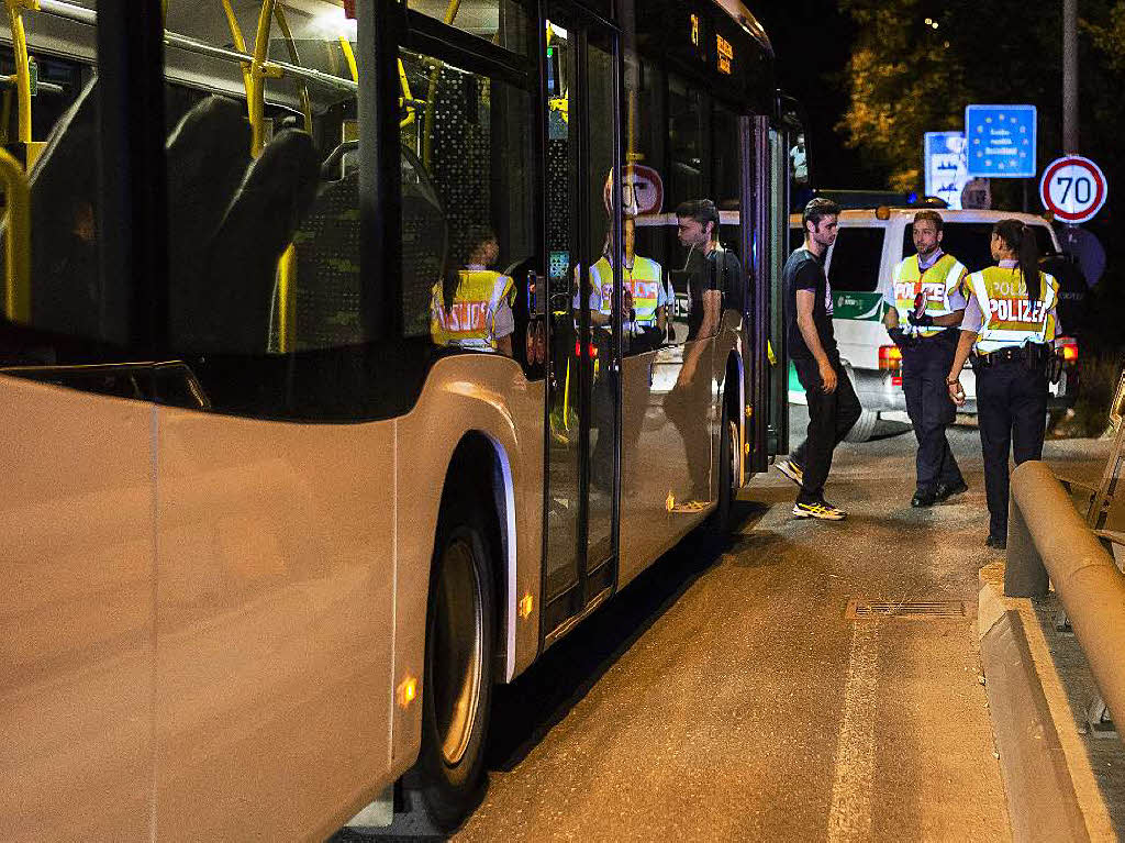 Ein Flchtling wird in einem Bus kontrolliert.