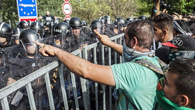 Polizisten und Flchtlinge stehen sich...wischen Serbien und Ungarn gegenber.   | Foto: dpa