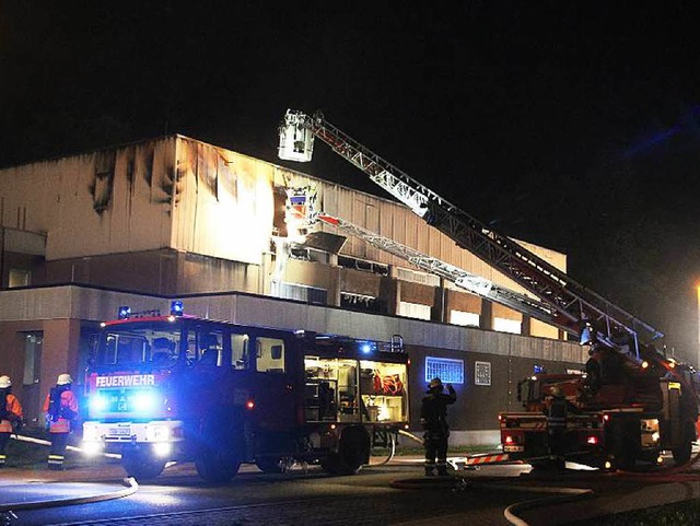 Einsatzkrfte der Feuerwehr lschen de...halle standen seit Samstag 330 Betten.  | Foto: dpa