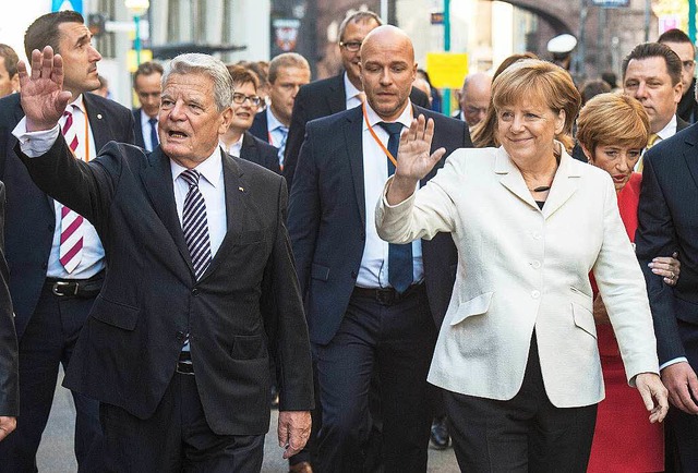 Bundeskanzlerin Angela Merkel und Bund...ent Joachim Gauck winken Besuchern zu.  | Foto: dpa