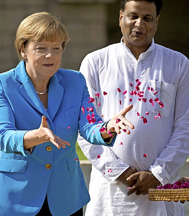 Angela Merkel streut Bltenbltter  au...inscherungssttte von Mahatma Gandhi.  | Foto: dpa