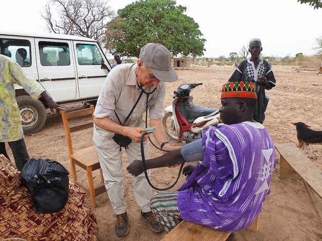 Der Arzt Ulf Stein behandelt im Freien einen Patienten.  | Foto: Privat