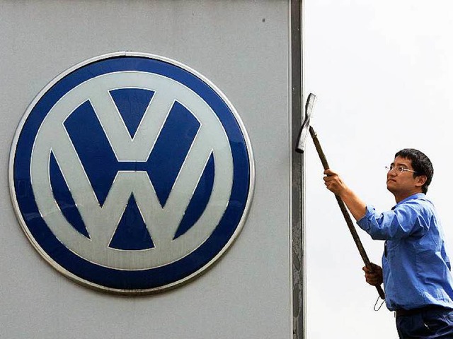 Ein Mitarbeiter  von VW in  Schanghai poliert die Marke.  | Foto: dpa