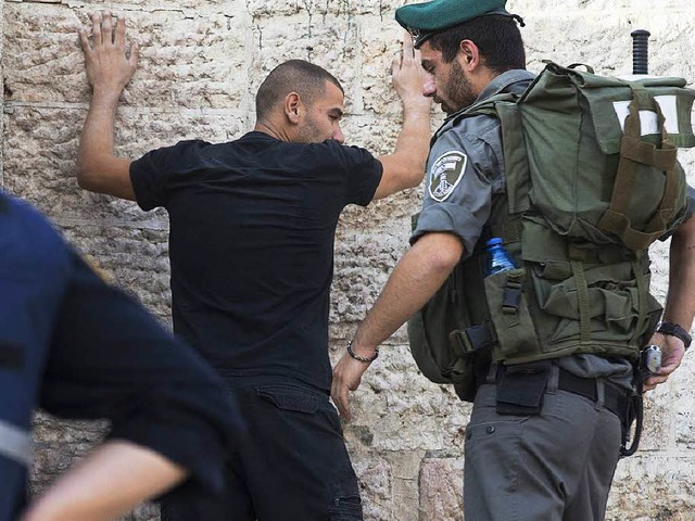 Ein israelischer Soldat kontrolliert einen Palstinenser in Jerusalem.  | Foto: dpa