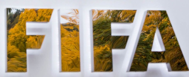 Herbstlaub spiegelt sich auf dem Namensschild des Blatter-Palastes in Zrich.   | Foto: dpa