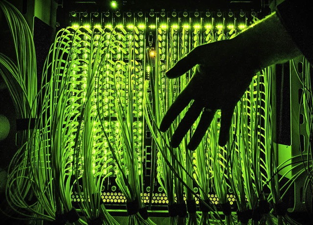 Ein Mann hlt eine Hand vor einen Vert...chwindigkeitsinternet zusammenlaufen.   | Foto: Daniel Reinhardt/dpa