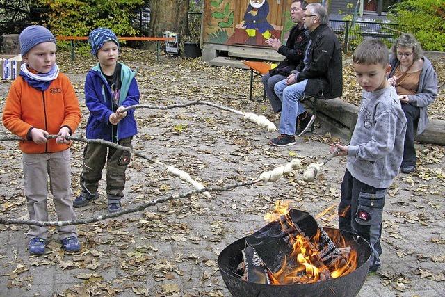 Kinder und Eltern begren gemeinsam den Herbst