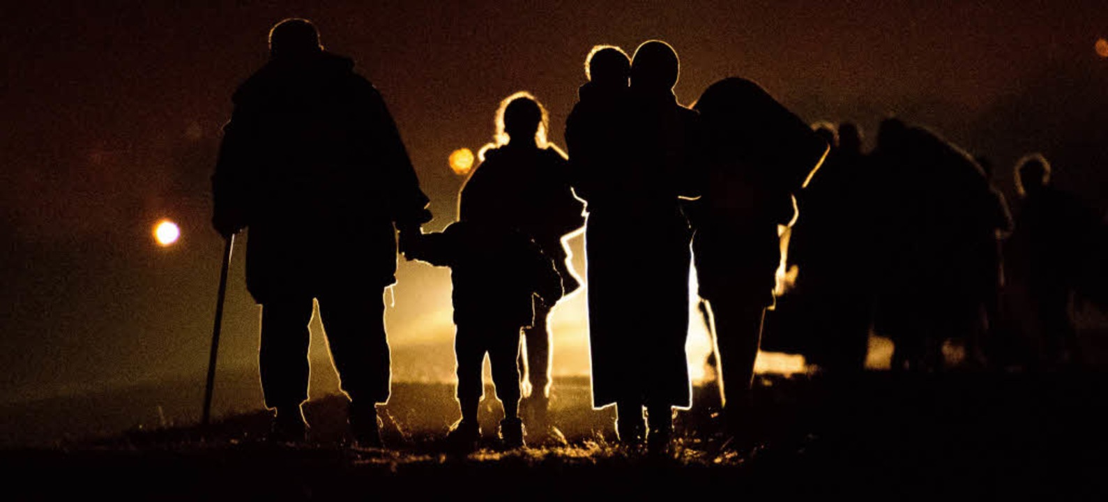 Flchtlingsfamilien laufen im Dunkeln auf das Camp Brezice zu.  | Foto: AFP