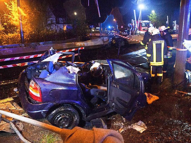Vllig zerstrt liegt ein Auto  am Sam...einem Bahnbergang neben den Gleisen.   | Foto: dpa