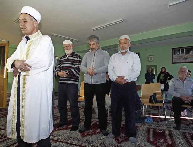 Imam Hakki Erol (vorne) spricht beim T...ntergrund schauen die Gste dabei zu.   | Foto:  Boris Burkhardt