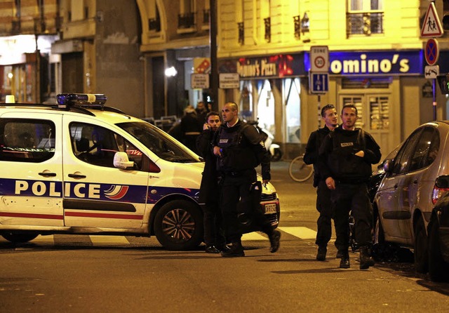 Polizisten sichern einen der Tatorte in Paris.  | Foto: afp