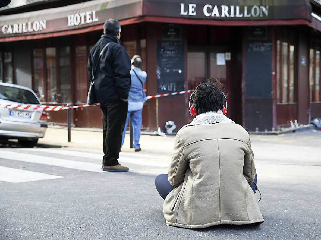 Eine Frau trauert vor der Bar Carillon in Paris.