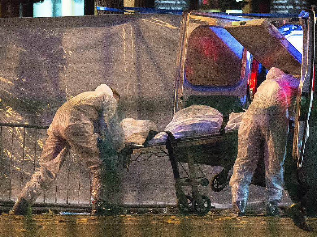 Rechtsmediziner laden vor dem Bataclan Theater in Paris eine Leiche in einen Transportwagen.