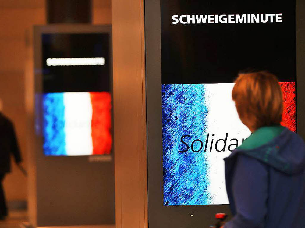 Anzeigentafeln erinnern in Kln an die Schweigeminute fr die Opfer von Paris.