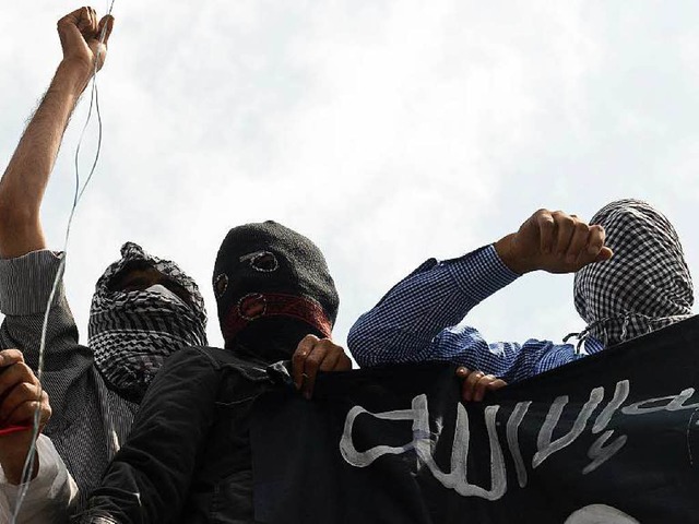 Vermummte  Mnner mit einer IS-Flagge;...tenzielle Gefhrder meist unauffllig.  | Foto: AFP
