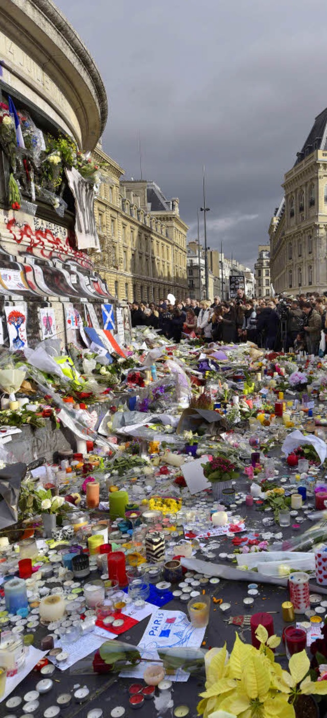 Menschen gedenken am Place de la Rpub...en Opfer des brutalen Terrorangriffs.   | Foto: afp