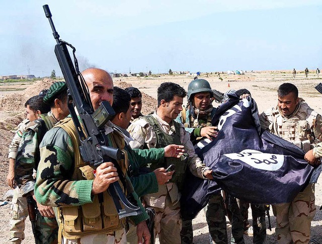 Kurdische Kmpfer erobern  eine IS-Fahne.  | Foto: dpa