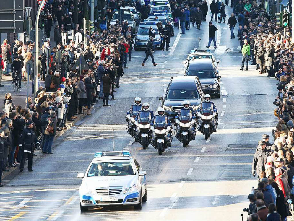Eine Polizeieskorte fhrt den Trauerzug an. Tausende Menschen nehmen Abschied von Helmut Schmidt.