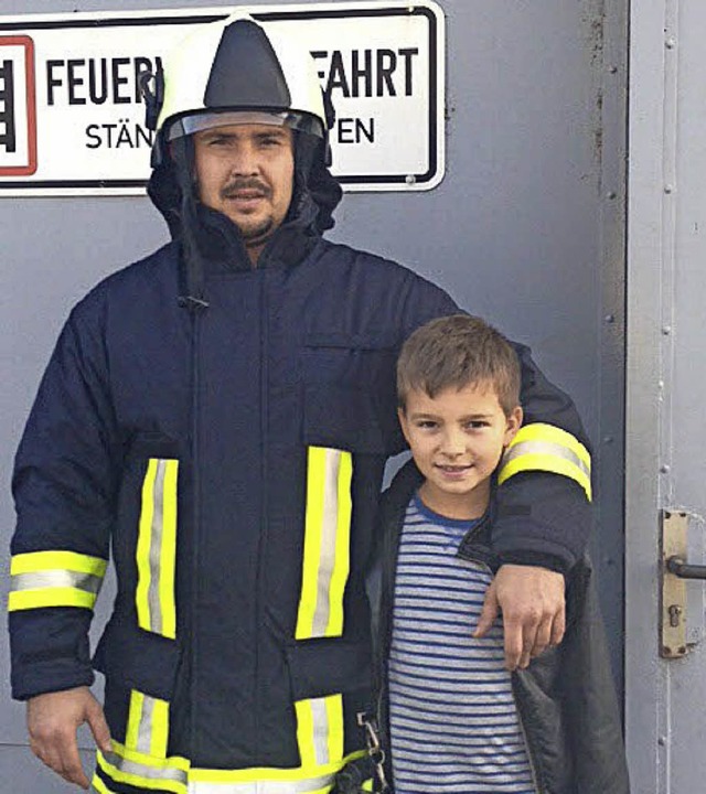 Feuerwehrmann Marius Scharff posiert in Schutzkleidung mit Gabriel Mellone.   | Foto: Privat