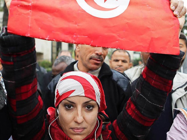 Mit der Flagge Tunesiens demonstriert die Frau gegen den Terror.   | Foto: DPA